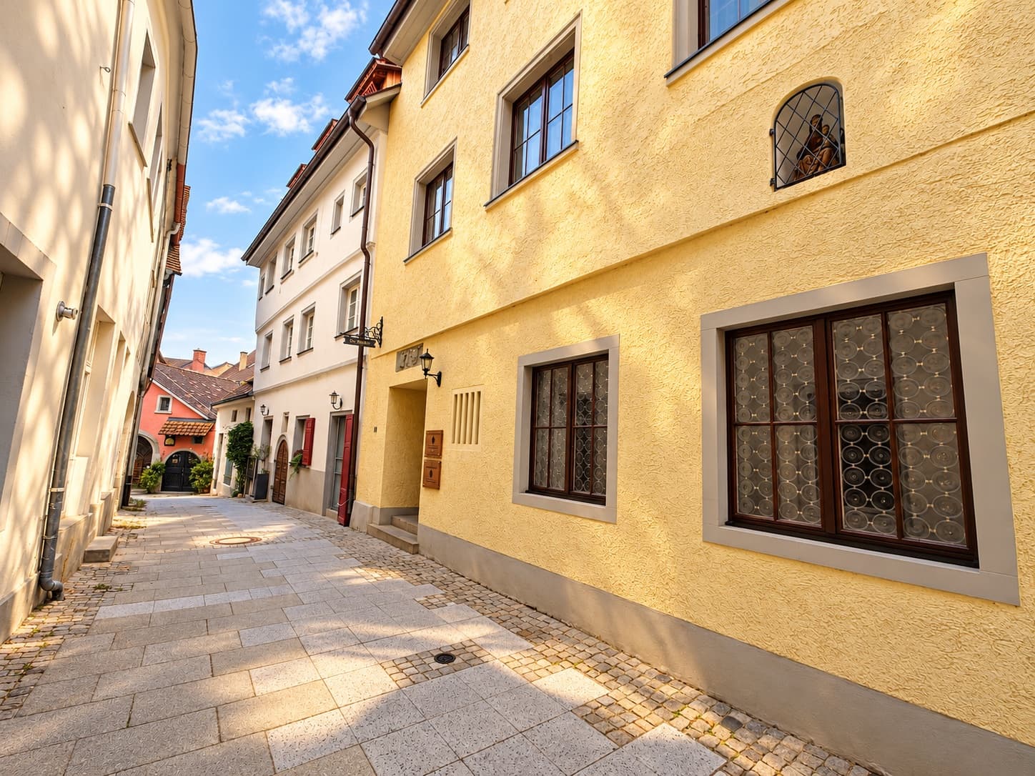Eingang der Praxis in der Turmgasse 11 in Überlingen: gelbes Altstadthaus mit Sprossenfenstern an einer gepflasterten Gasse